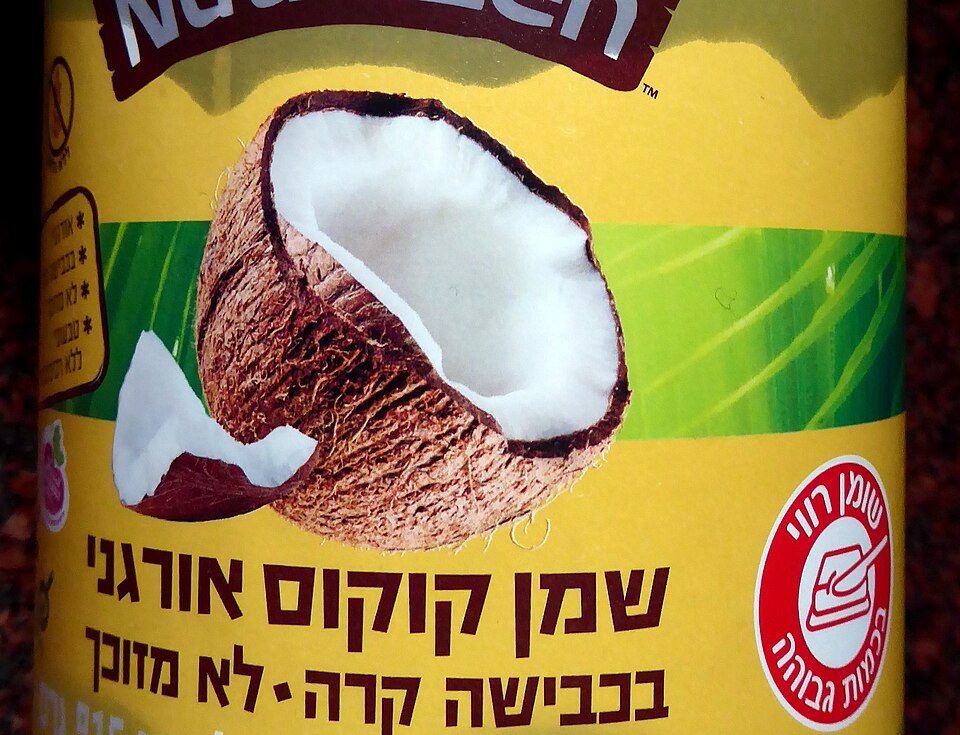 A jar of coconut oil with a high saturated fat warning label
